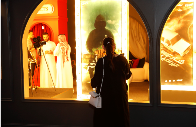 Visitor viewing film posters at Discover Saudi Cinema showcase in Venice, presented by the Saudi Ministry of Culture.