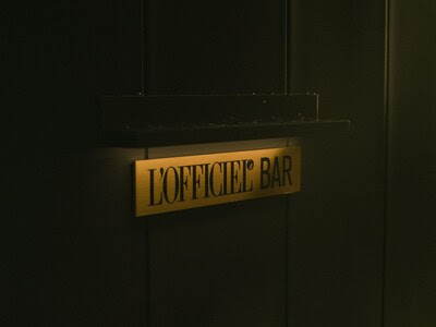 Golden L’OFFICIEL BAR sign glowing on entrance wall, representing TGE’s luxury expansion in Omotesando, Japan.