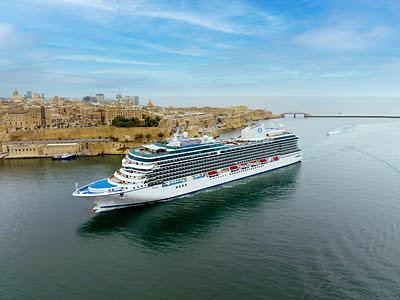 Oceania Cruises luxury ship sailing toward a scenic global destination
